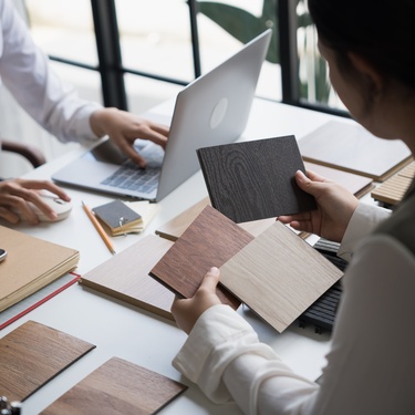 A creative engineer presenting a few eco friendly wooden material samples for sustainable home decor.