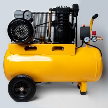 Yellow portable air compressor with a large tank, black motor, pressure gauges, handle, and wheels on a gray background.